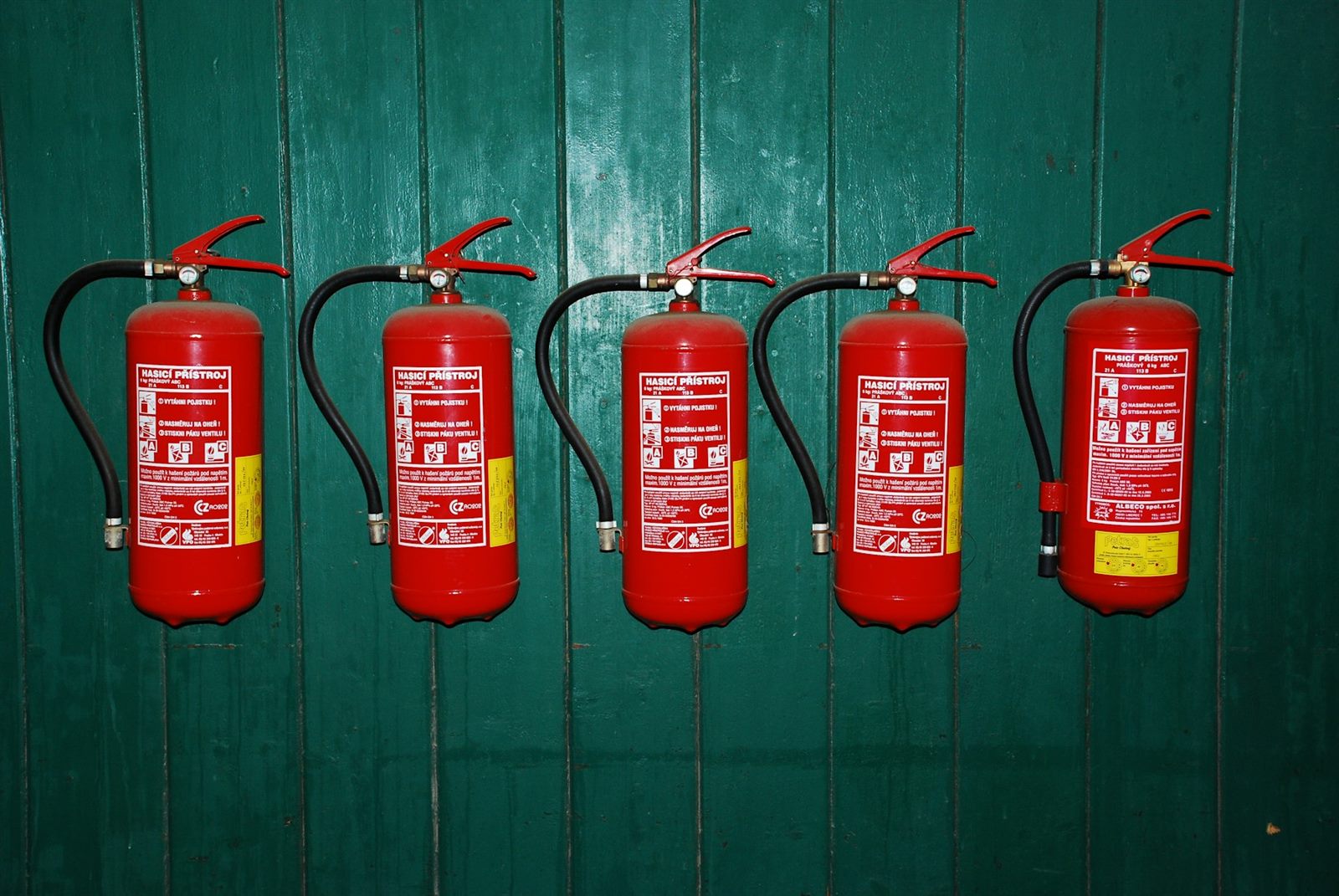 Fila de extintores rojos montados en una pared